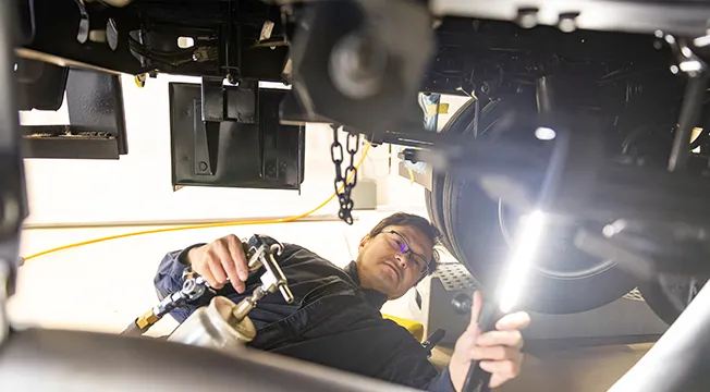車の裏に入って整備をしている様子